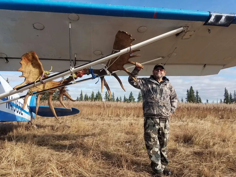 Wayne Kubat with moose antlers lashed to the wing struts of his Super Cub